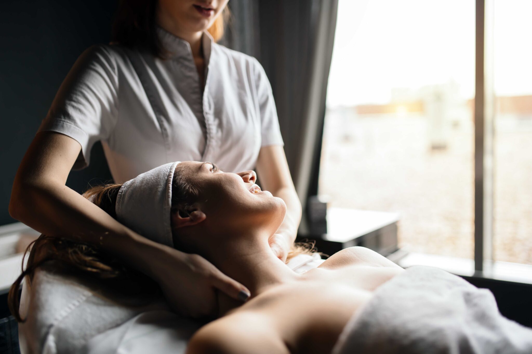 Massage therapist massaging beautiful cute young brunette